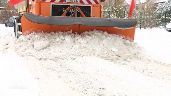 Ein Räumfahrzeug räumt Schnee zur Seite.  