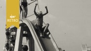 Kind rutscht eine Rutsche im Freibad hinunter (1965)  