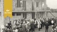 Arbeiter und Gäste vor einem Gebäude beim Richtfest (1965)  
