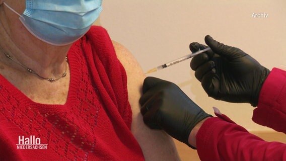 Eine ältere Dame bekommt eine Impfung in der Praxis ihres Hausarztes.  
