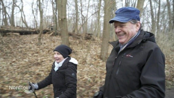 Marianne und Uwe Freitag walken gut gelaunt durch den Wald.  