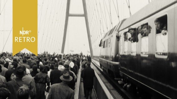 Zug und zahlreiche Fußgänger zur Einweihung auf der neuen Fehmarnsundbrücke 1963  