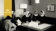 Diakonissinen in Uniform beim gemütlichen Beisammensein in einem Wohnzimmer (1964)  