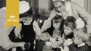 Zwei Kinderpflegerinnen des DRK bei der Betreuung im Kindergarten 1964  