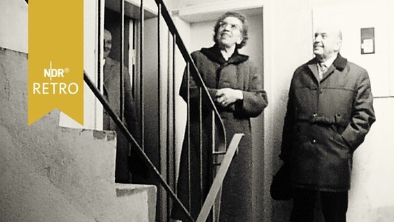 Schleswig-Holsteins Sozialministerin Ohnesorge mit einem Rentner in einem Treppenhaus (1964)  