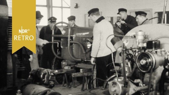 Lehrer erklärt Berufsschülern einen Traktor (1964)  