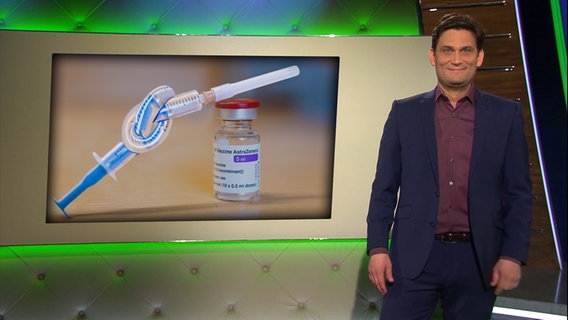 Christian Ehring neben einer verknoteten Impfspritze.  