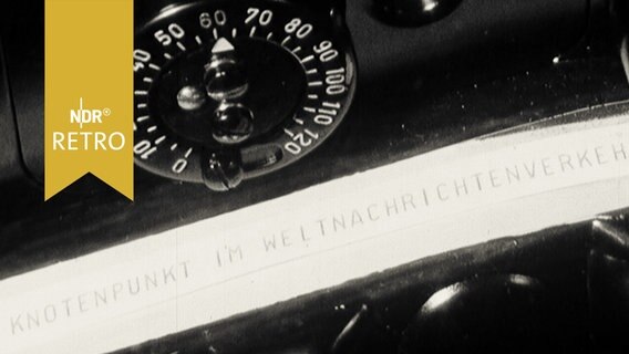 Auf einem Tickerstreifen erscheint die Schriftzeile "Knotenpunkt im Weltnachrichtenverkehr" in der gleichnamigen Hamburger Ausstellung 1965  