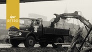 Bagger lädt in den Wallanlagen Erde in einen LKW (1964), im Hintergrund ein Hamburger Gerichtsgebäude  