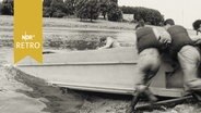 Männer schieben einen Schwimm-Ponton zum Behelfsbrückenbau in die Weser (1964)  