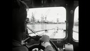 Blick von der Brücke einer Barkasse auf Hafenkräne in Lübeck 1964  