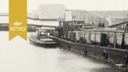 Frachter längsseits im Hafen, dahinter die Seeschleuse in Wilhelmshaven 1964  