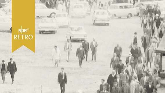 Zahlreiche PKW und Menschen auf dem Weg zum Holstein-Stadion in Kiel 1964  