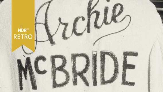 Trainingsjacke des Boxers mit seinem Schriftzug "Archie McBride" hängt auf einem Bügel (1964)  