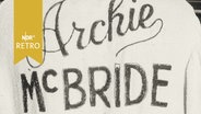 Trainingsjacke des Boxers mit seinem Schriftzug "Archie McBride" hängt auf einem Bügel (1964)  