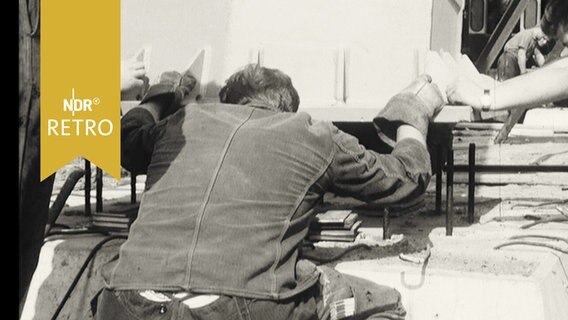 Arbeiter bei der Einpassung eines Brückenpylons auf seinen Betonsockel 1964  