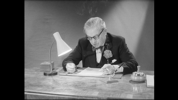Lord Boothby sitzt an einem Schreibtisch.  