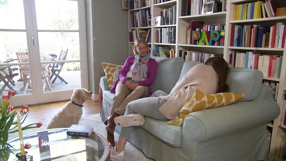 Eine 14-Jährige sitzt nach einer Covid-19-Infektion mit ihrer Mutter auf einem Sofa.  
