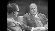 Zwei Männer sitzen sich gegenüber und führen ein Gespräch (Archivbild)  
