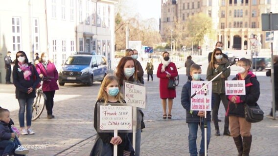 Kinder und Erwachsene demonstrieren vor der Staatskanzlei in Schwerin.  