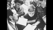Nahaufnahme einer Menschenmenge welche liest und diskutiert (Archivbild)  
