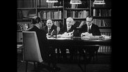 Vier Männer sitzen um einen Tisch und diskutieren (Archivbild)  