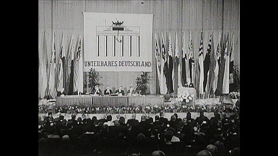 Ein voller Saal, zu sehen das Plakat mit der Aufschrift "Unteilbares Deutschland".  