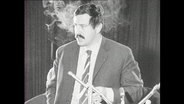 Günter Grass spricht in ein Mikrofon.  