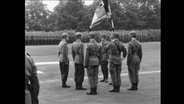 Soldaten stehen in Uniform aufgereiht.  