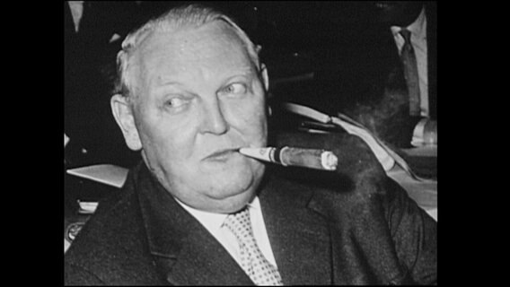 Ludwig Erhard raucht eine Zigarre.  