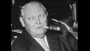 Ludwig Erhard raucht eine Zigarre.  