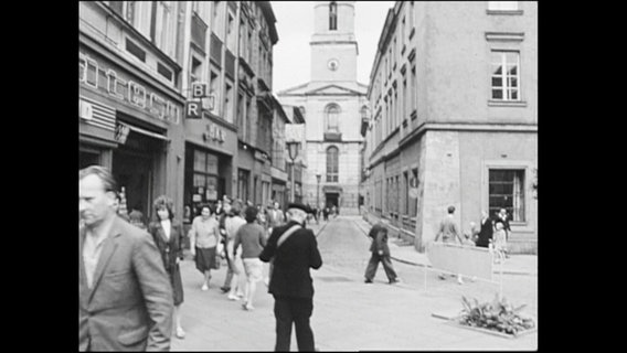 Menschen laufen durch eine Straße in Grünberg.  
