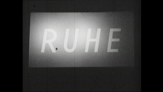Das illuminierte Wort "Ruhe" auf dunklem Grund  