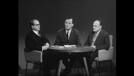 Drei Männer sitzen um einen Tisch und diskutieren (Archivbild)  