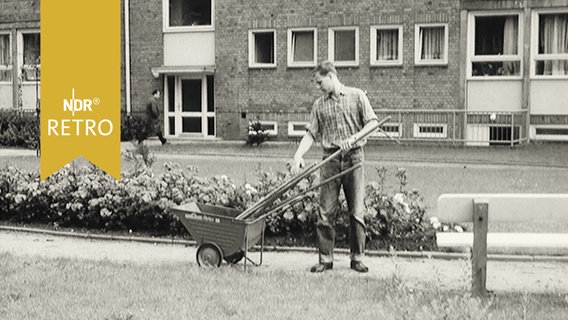 Ersatzdienst leistender junger Mann mit Straßenfegerausrüstung auf einem Gehsteig 1964  