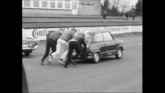 Drei Männer schieben ein Auto an (Archivbild)  