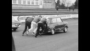 Drei Männer schieben ein Auto an (Archivbild)  