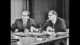 Zwei Männer sitzen an einem Tisch und sind in einem Gespräch (Archivbild)  