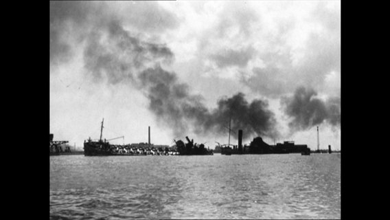 Kriegsschiffe auf dem Wasser, darüber dichte Rauchwolke (Archiv-Bild).  