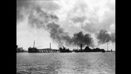 Kriegsschiffe auf dem Wasser, darüber dichte Rauchwolke (Archiv-Bild).  