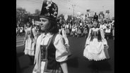 Frauen in Warschau marschieren in traditionellen Kleidern.  