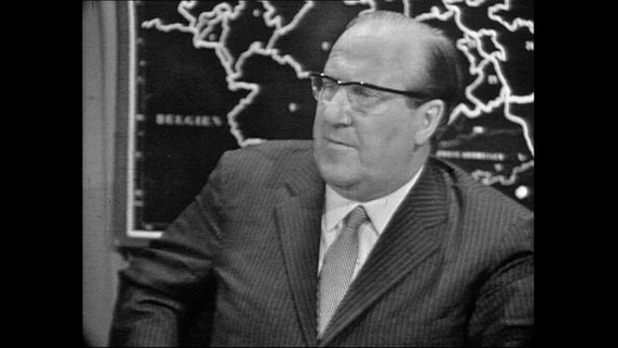 Franz Meyers, Ministerpräsident von NRW sitzt vor einer Landkarte.  