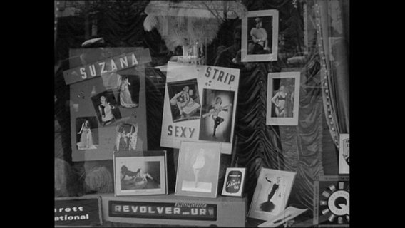 Das Schaufenster eines Strip-Clubs mit Fotos von Frauen in Unterwäsche.  