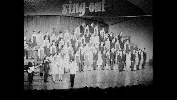 Die Gesangsgruppe "Sing out Deutschland" steht auf einer Bühne.  