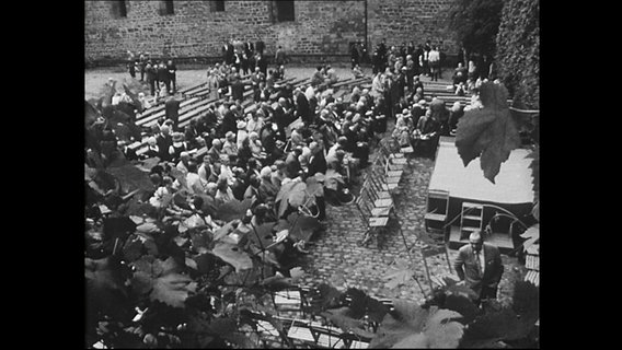 Das Publikum der Lippoldsberger Dichtertage sitzt auf Stühlen vor der Bühne in einem Innenhof (Archivbild).  