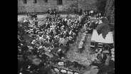 Das Publikum der Lippoldsberger Dichtertage sitzt auf Stühlen vor der Bühne in einem Innenhof (Archivbild).  