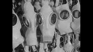 Dutzende Gasmasken hängen aufgereiht nebeneinander (Archivbild)  