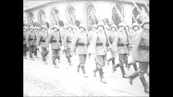 Soldaten marschieren in einer Formation.  