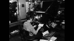 Ein Mann tippt auf einer Schreibmaschine.  
