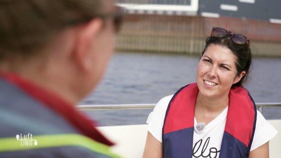 Vanessa Kossen an Bord eines Schifffes im Gespräch mit einem Mann.  